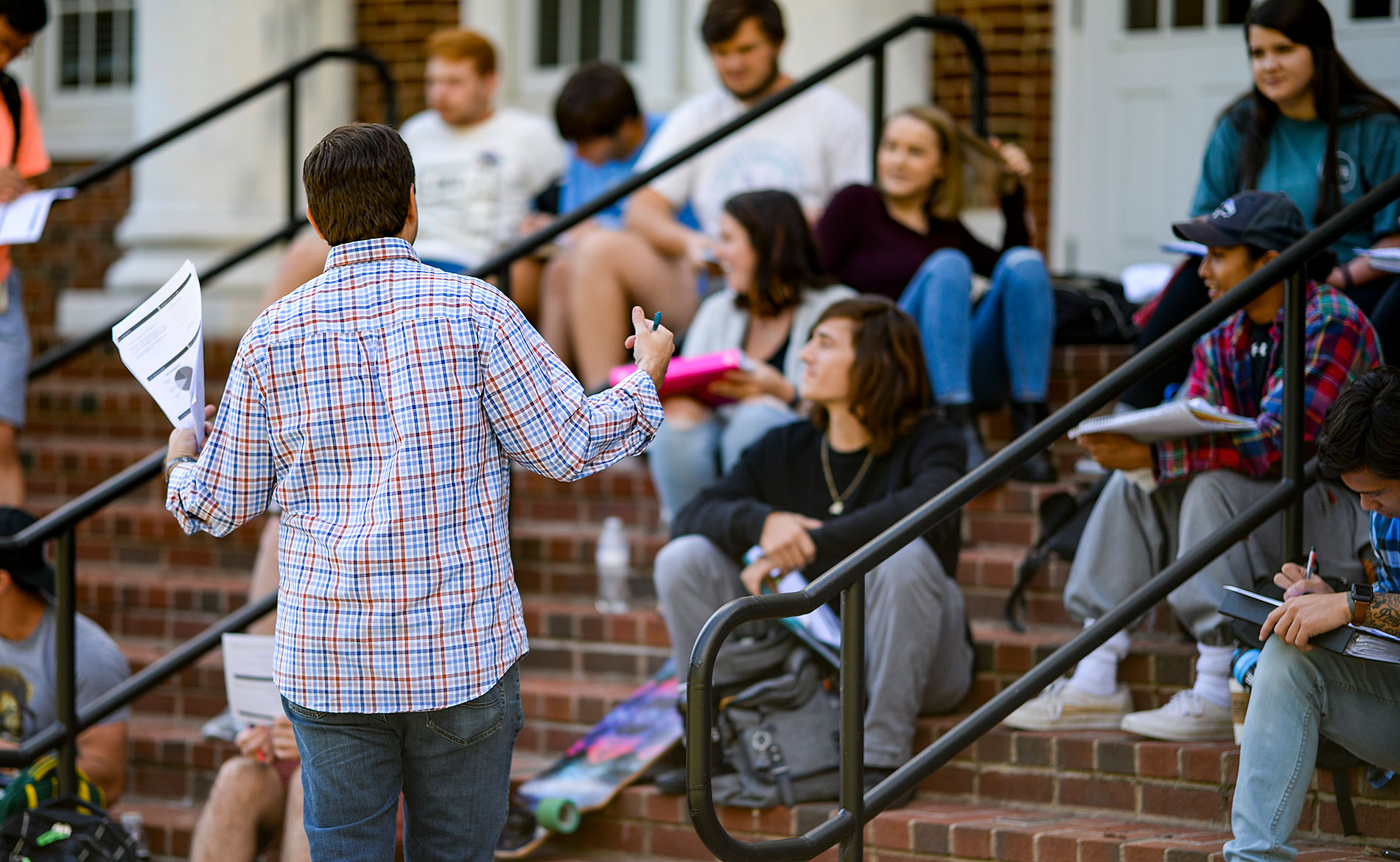 Economics professor teaching students outside on the stairs