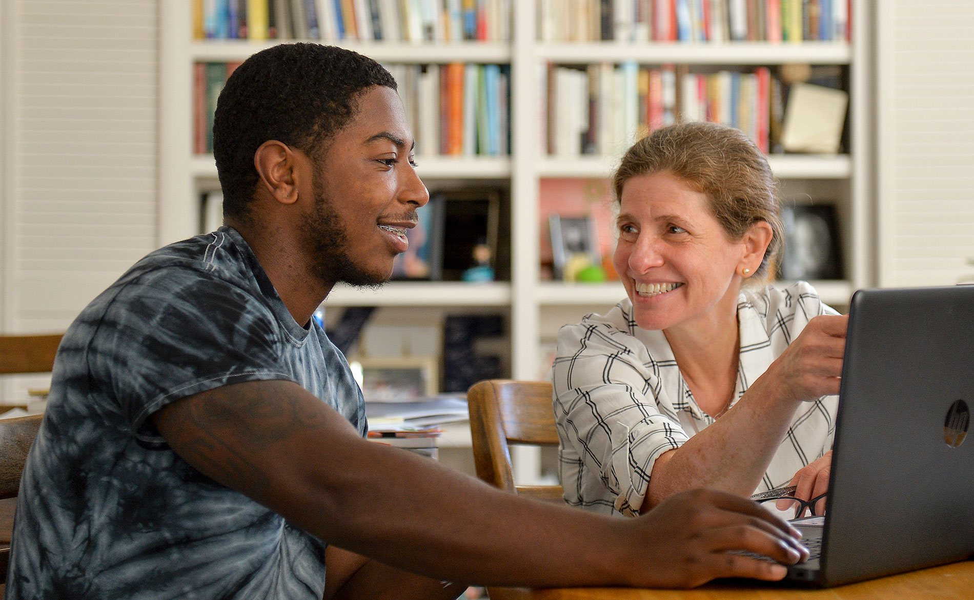 A student and A professor working on a laptop