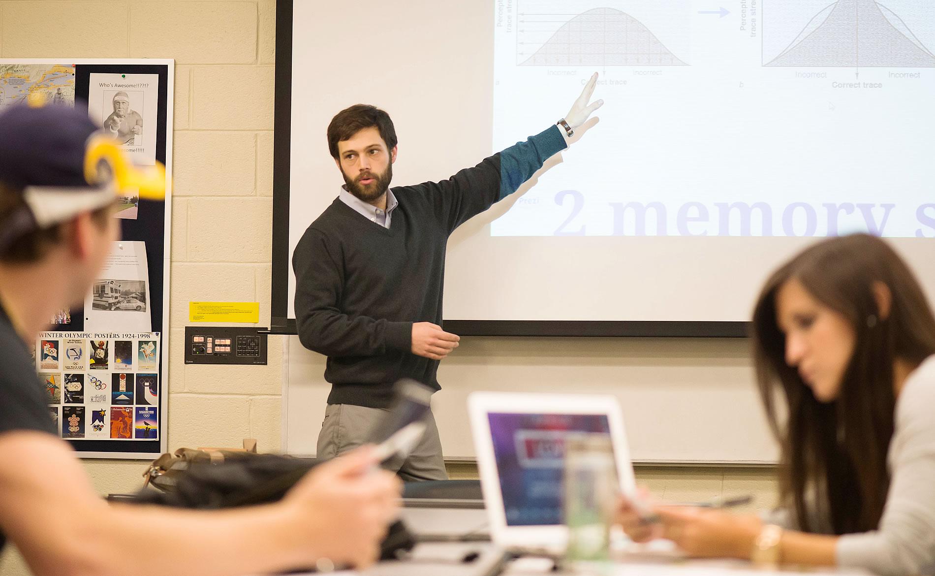 Professor pointing at the board in a classroom